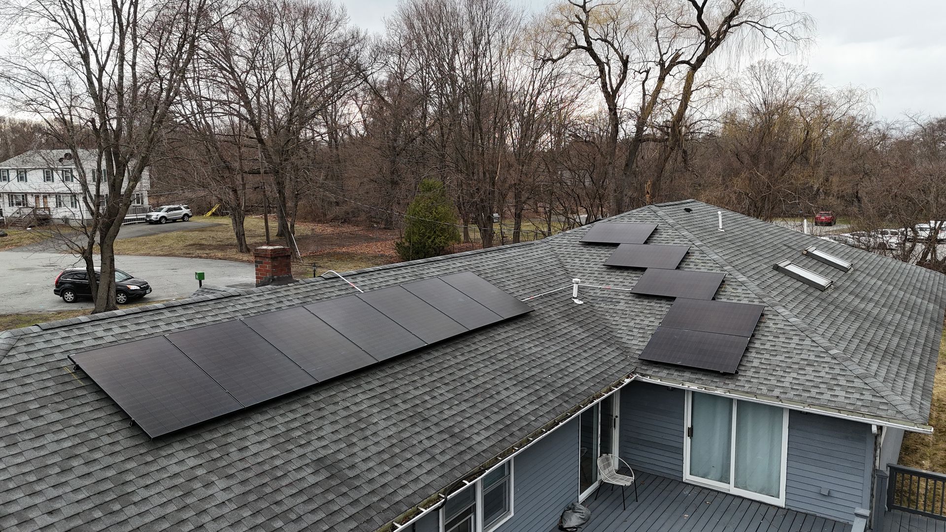 An aerial view of a house with solar panels on the roof.