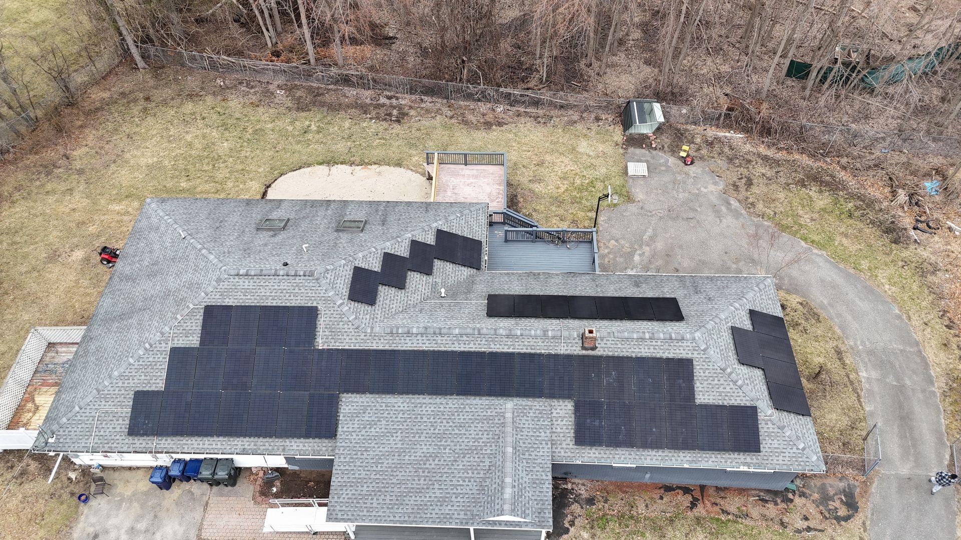 An aerial view of a house with solar panels on the roof.