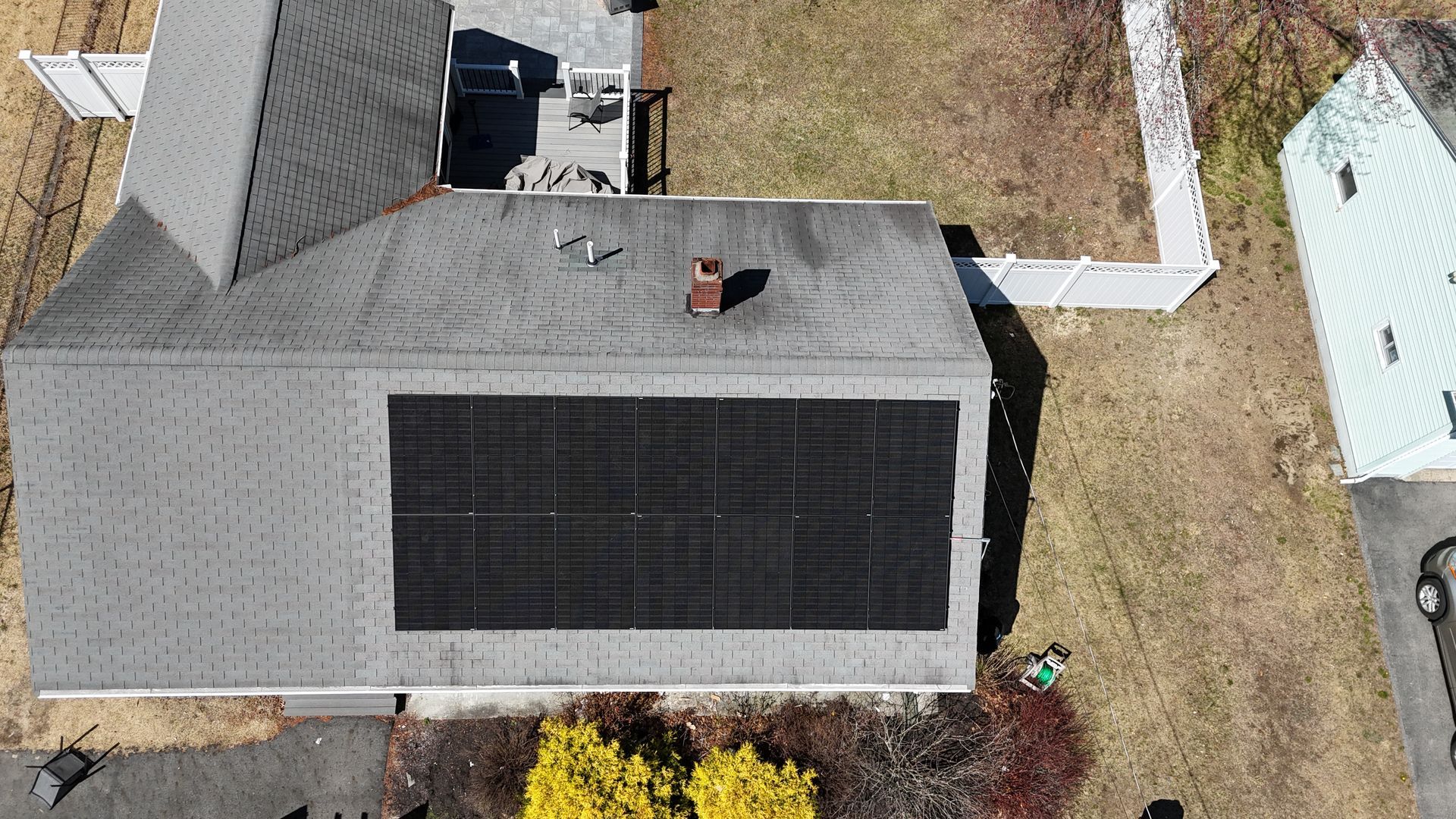An aerial view of a house with solar panels on the roof.