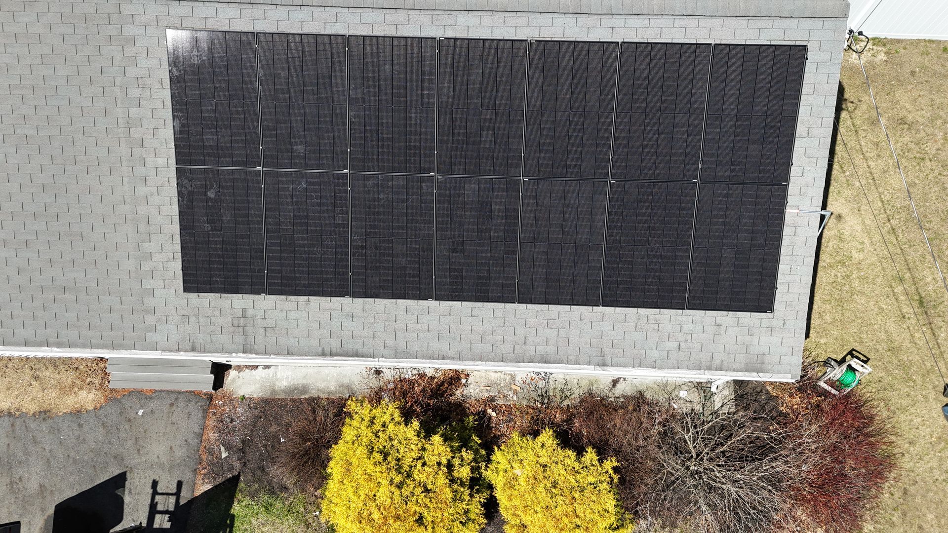 An aerial view of a house with solar panels on the roof.