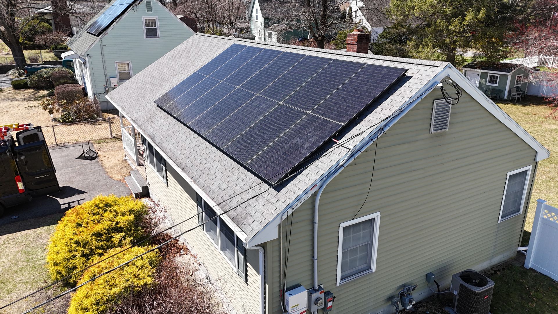 An aerial view of a house with solar panels on the roof.