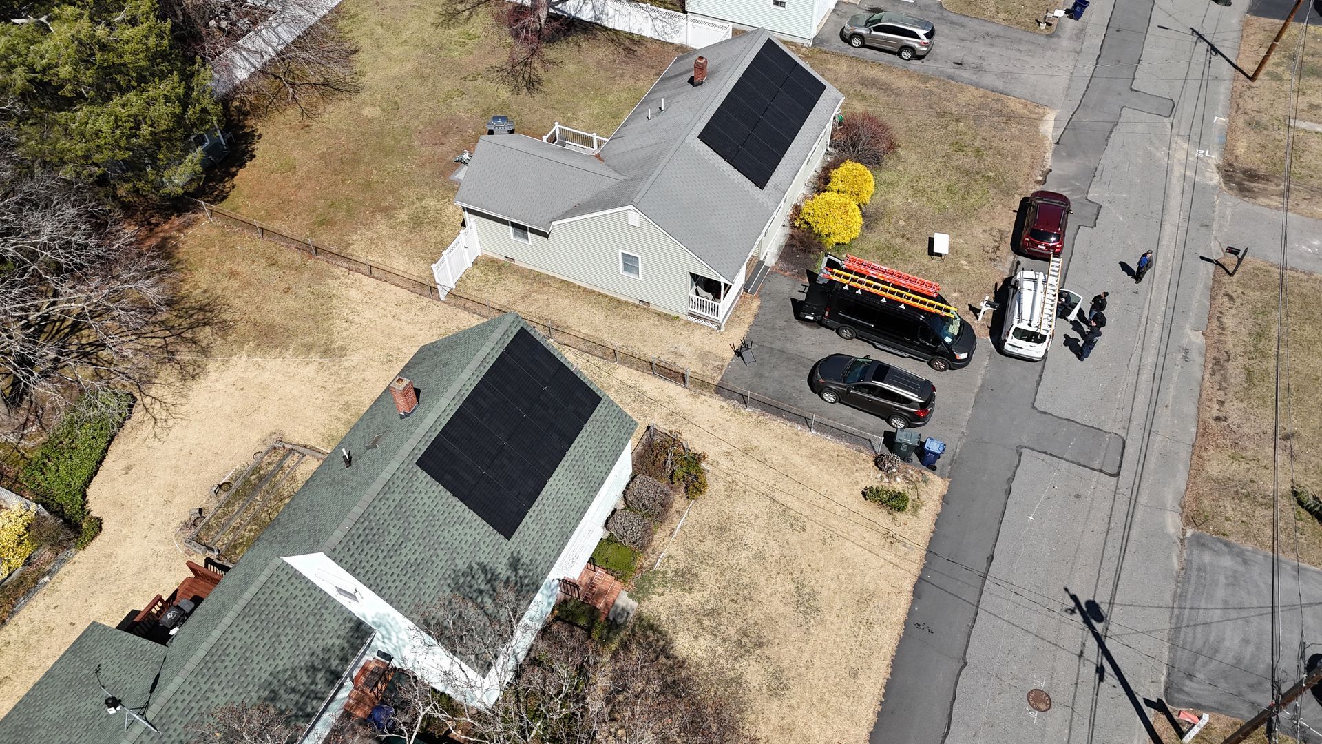 An aerial view of a residential area with solar panels on the roofs of houses.