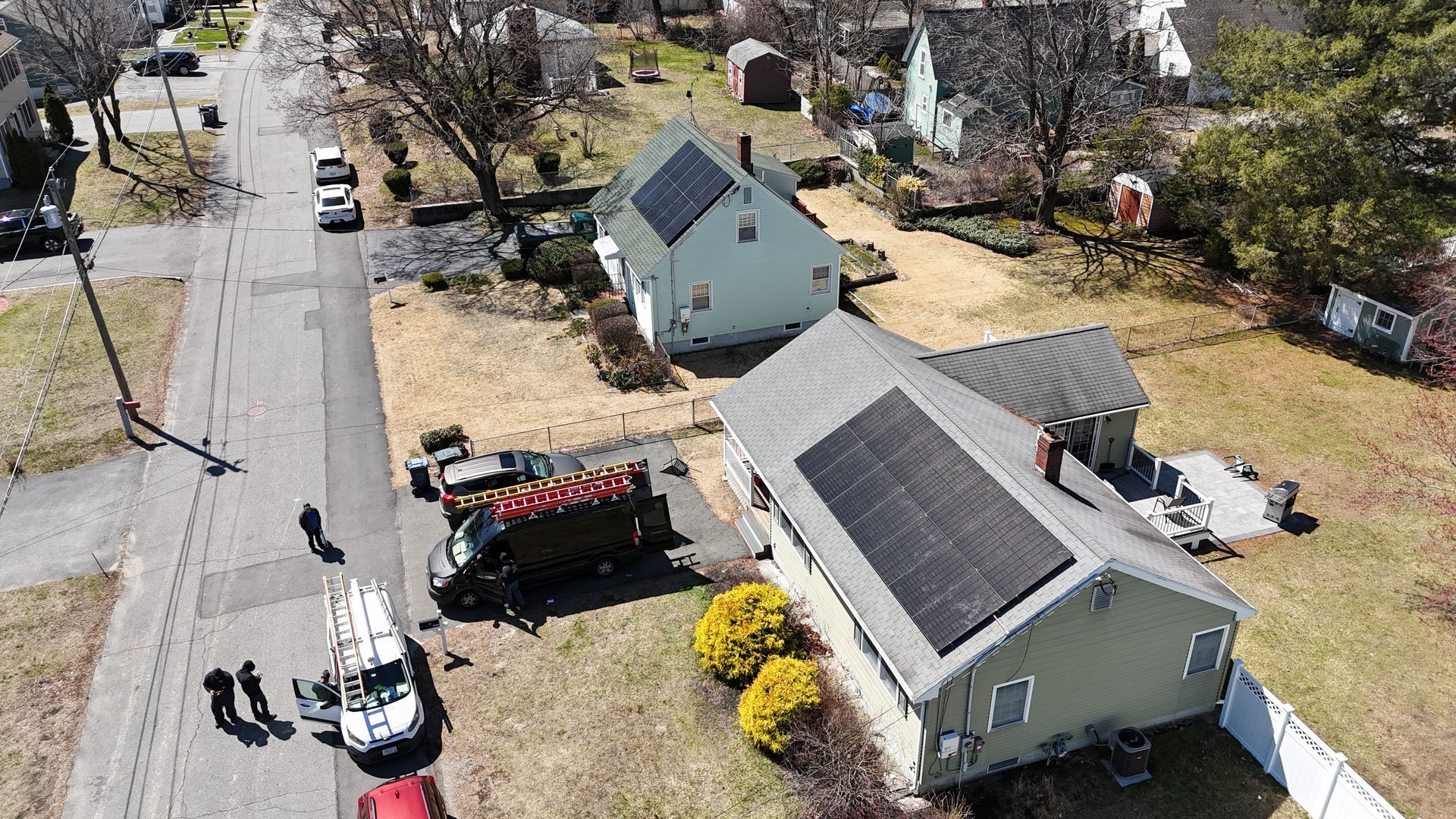 An aerial view of a house with solar panels on the roof.