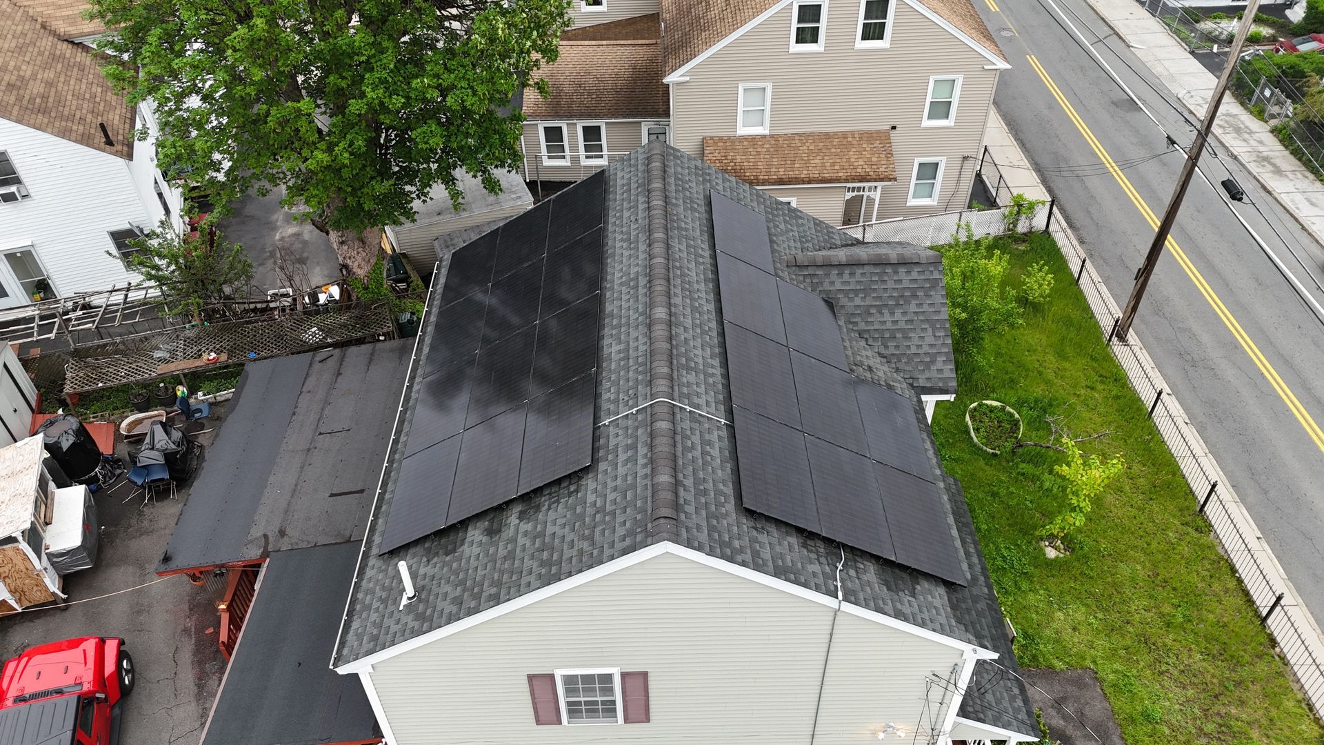 An aerial view of a house with solar panels on the roof.