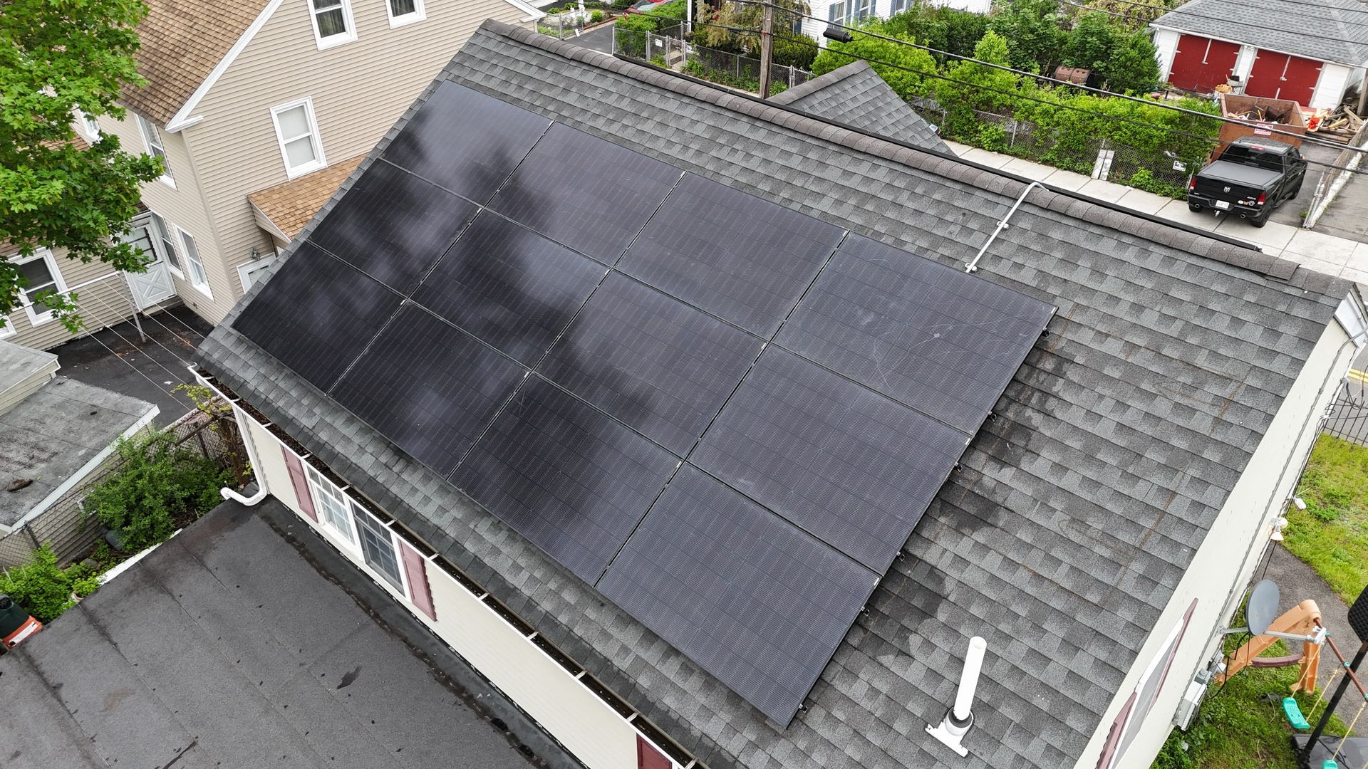 An aerial view of a house with solar panels on the roof.