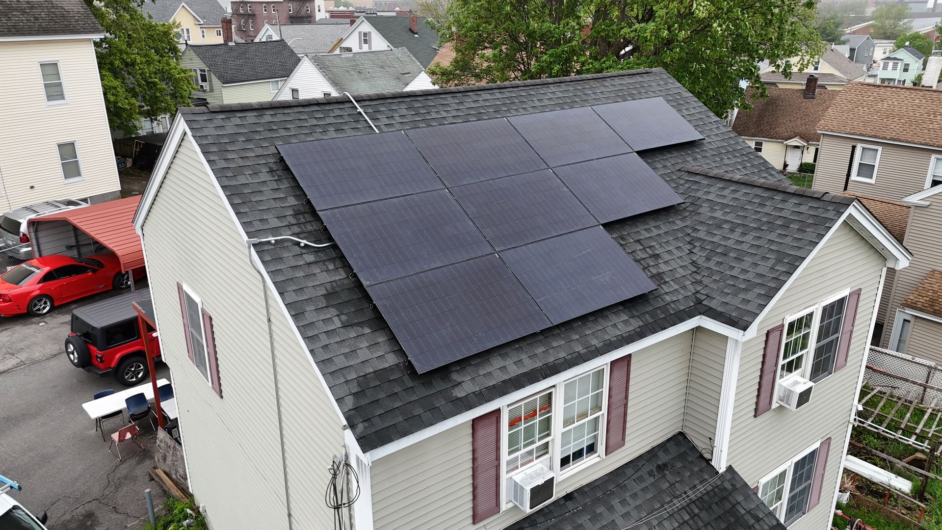 An aerial view of a house with solar panels on the roof.