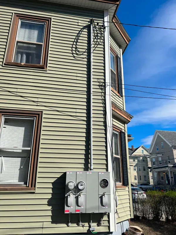 A green house with a meter on the side of it.
