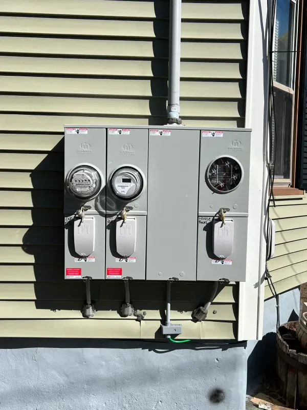A electrical box is mounted on the side of a house.