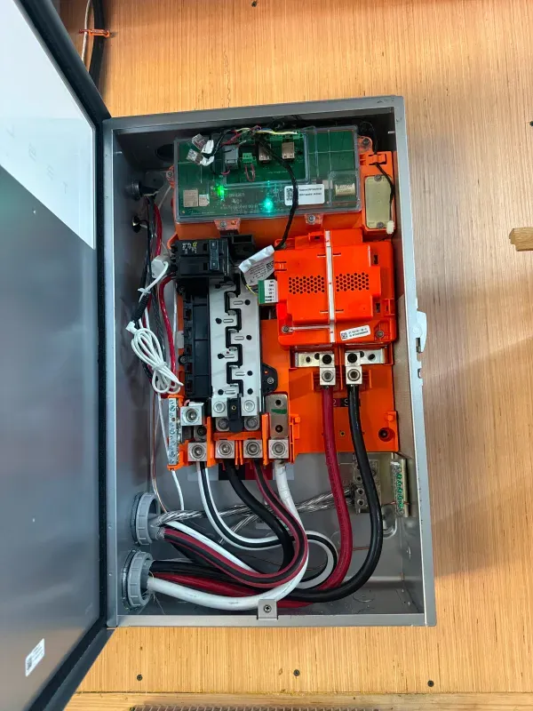 A close up of a electrical box with a lot of wires coming out of it.