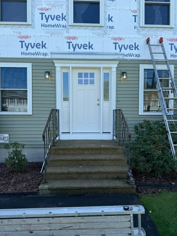 A house with a white door and stairs is being remodeled.