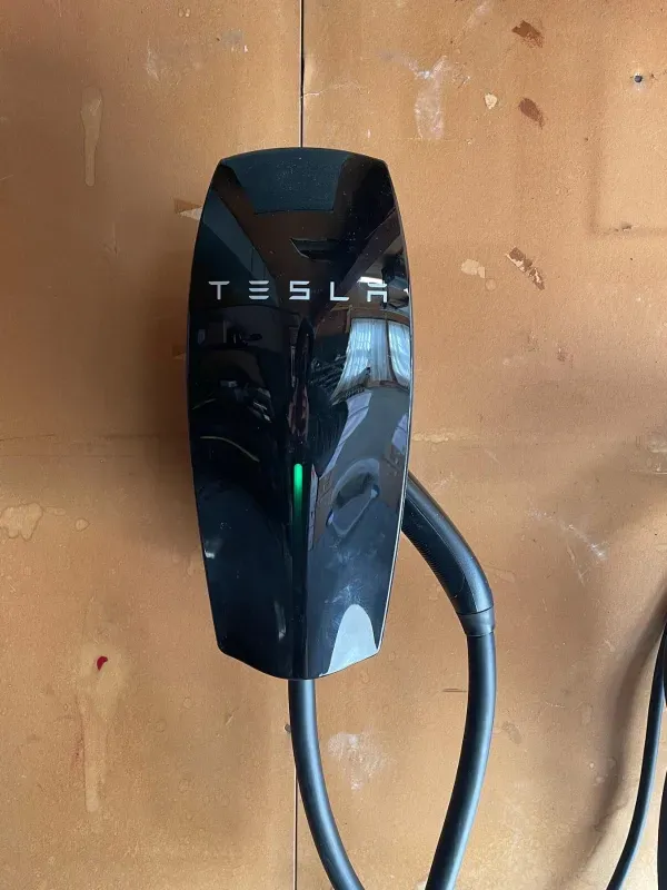 A tesla charging station is attached to a wall