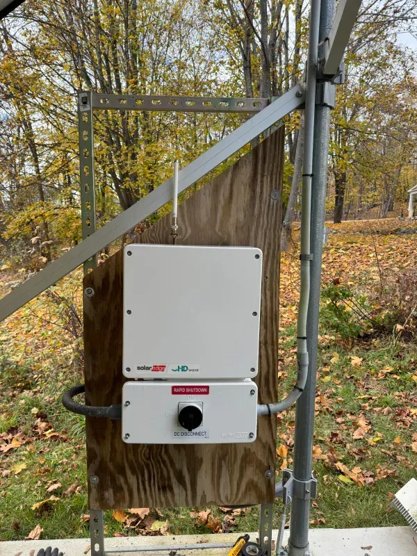 A white box is attached to a wooden wall.