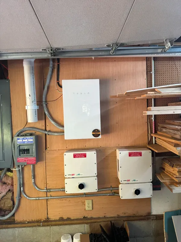 A white box is hanging on a wooden wall in a garage.