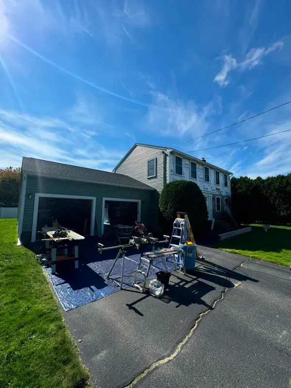 A house is being painted on a sunny day.