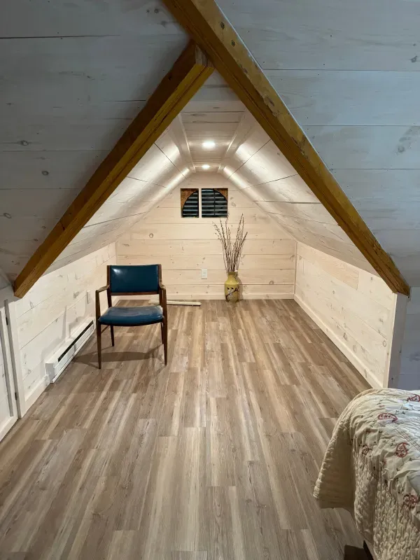 There is a chair and a bed in the attic.