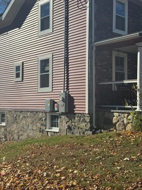 A house with a pink siding and a black roof