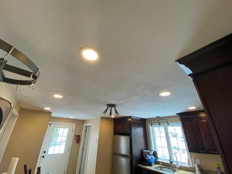 A kitchen with a white ceiling and brown cabinets