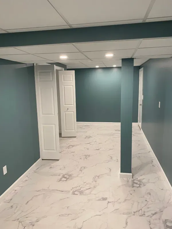 A basement with blue walls and white marble floors.