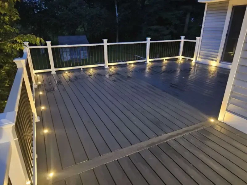 A deck with lights on it and a white railing