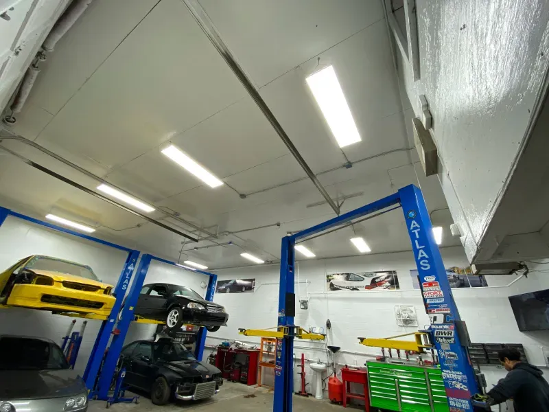 A man is working on a car in a garage.