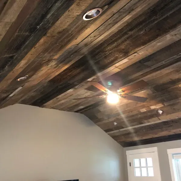 A room with a wooden ceiling and a ceiling fan