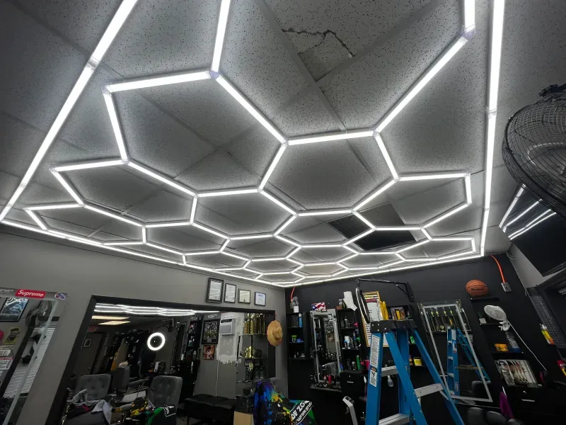 A room with a ceiling that looks like a honeycomb and a ladder.