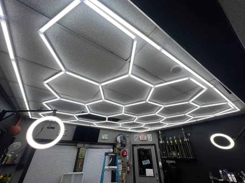 A ceiling with a honeycomb pattern and a ladder in the background