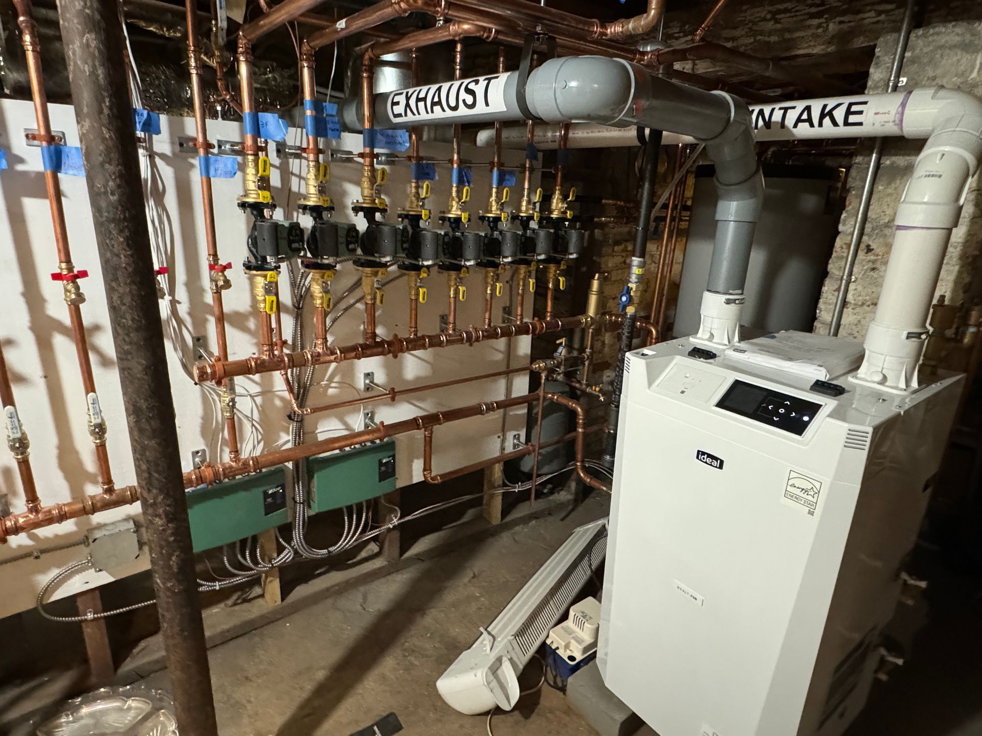 A boiler in a basement with a sign that says exhaust intake