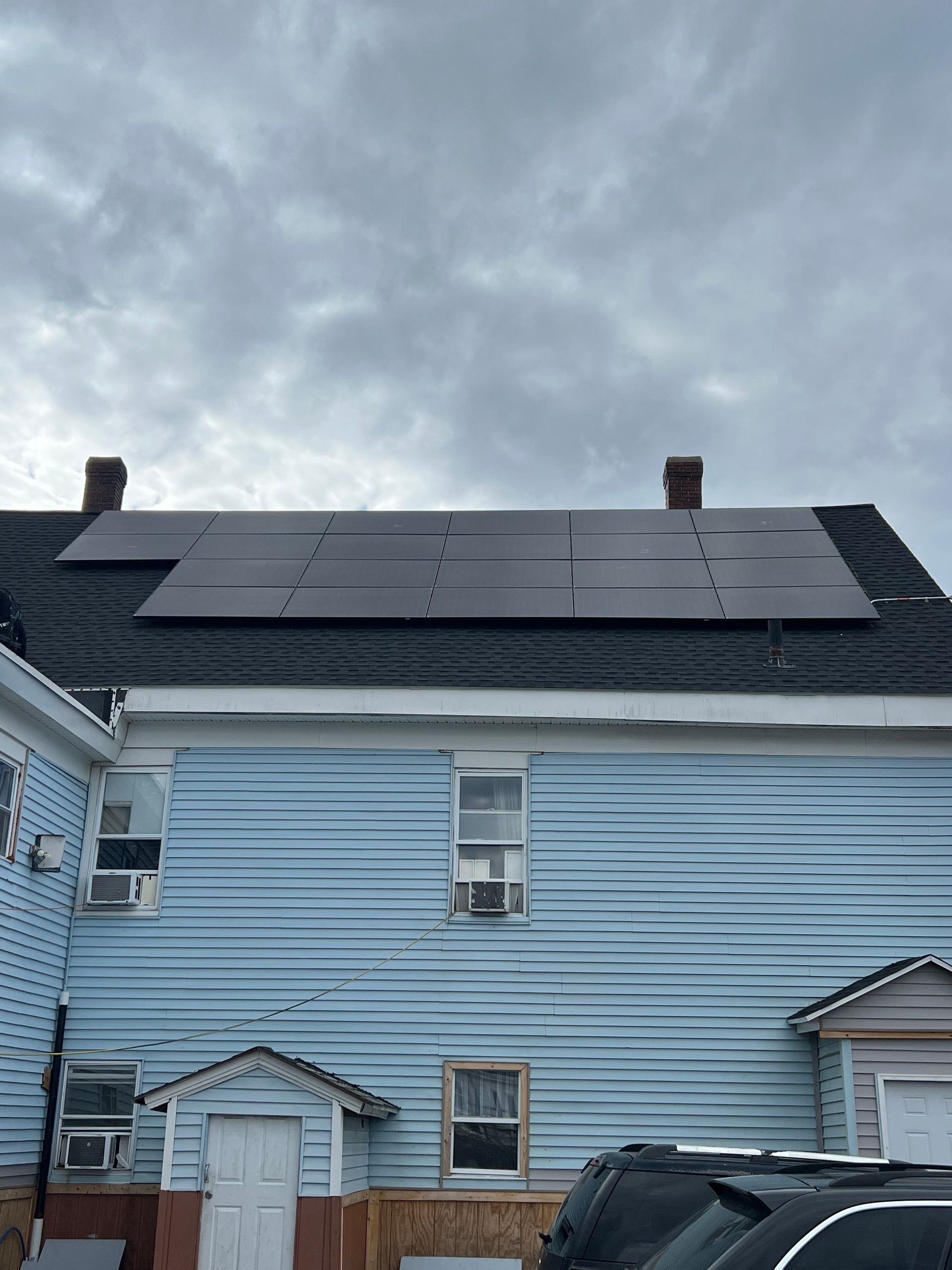 A blue house with solar panels on the roof.