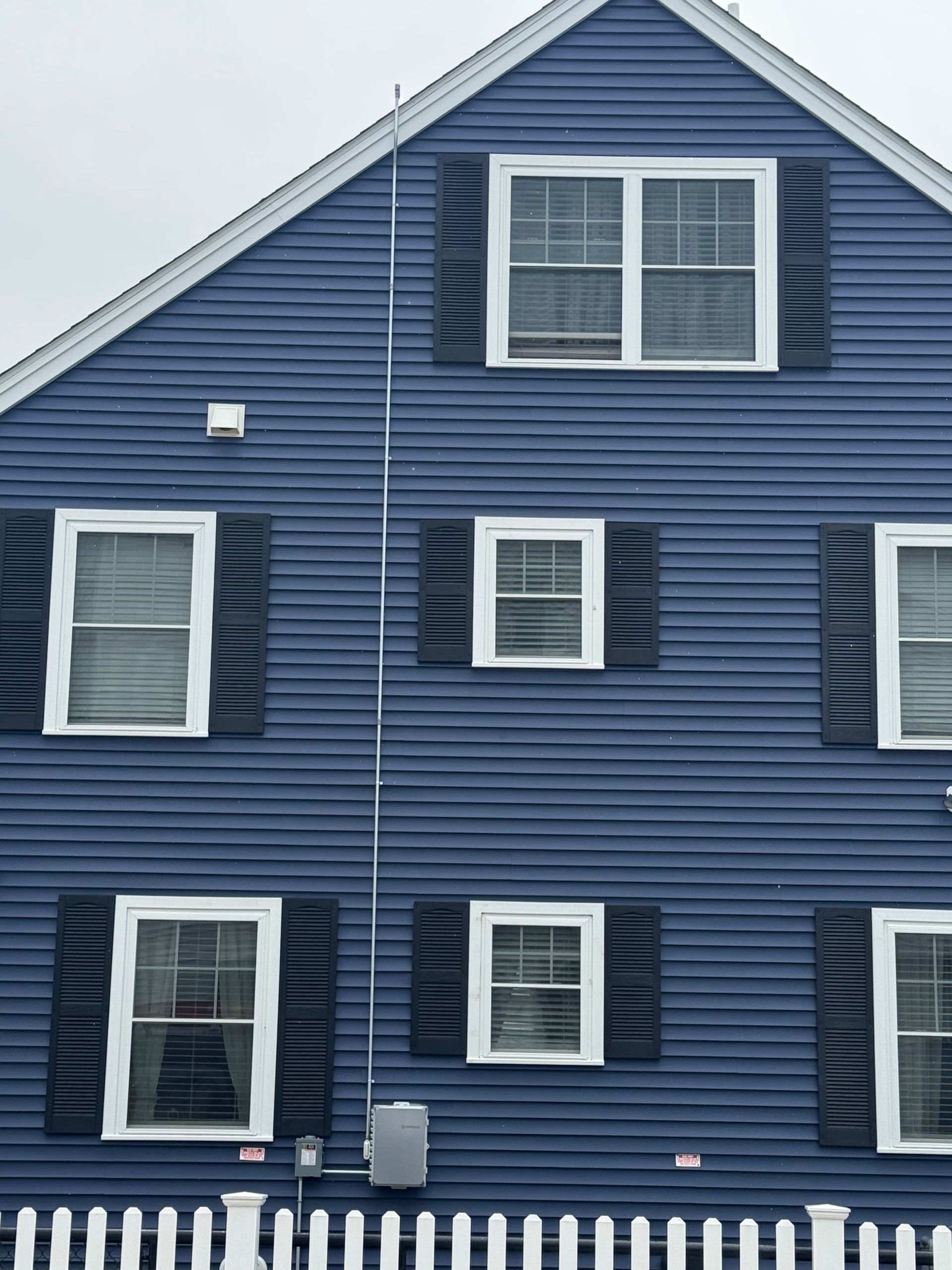 A blue house with black shutters and white trim