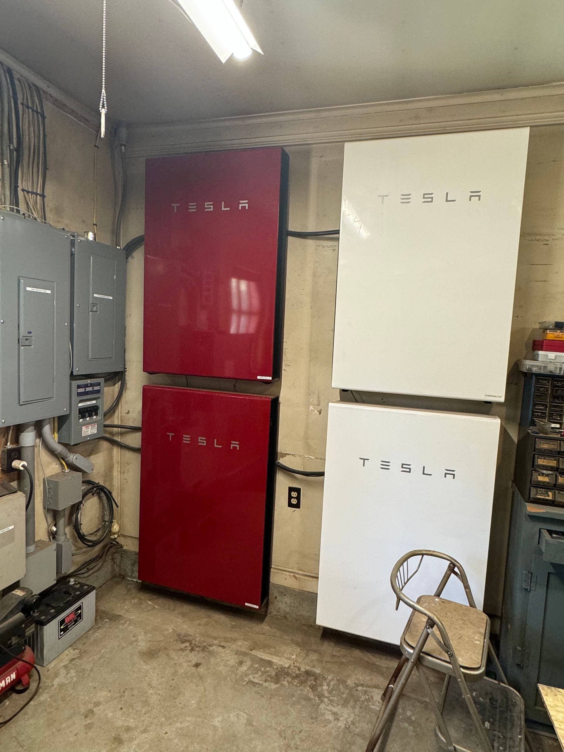Three tesla solar panels are stacked on top of each other in a room.