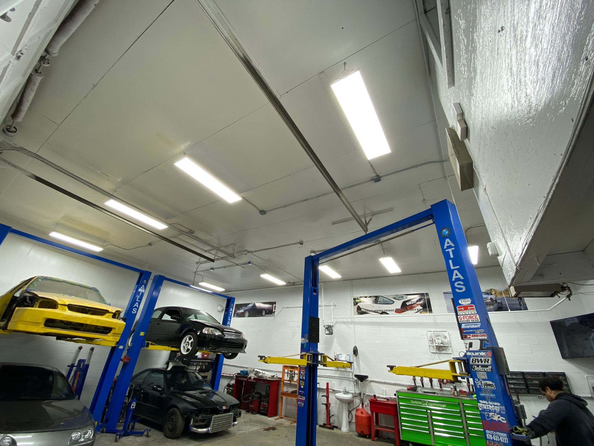 A car is sitting on a lift in a garage.