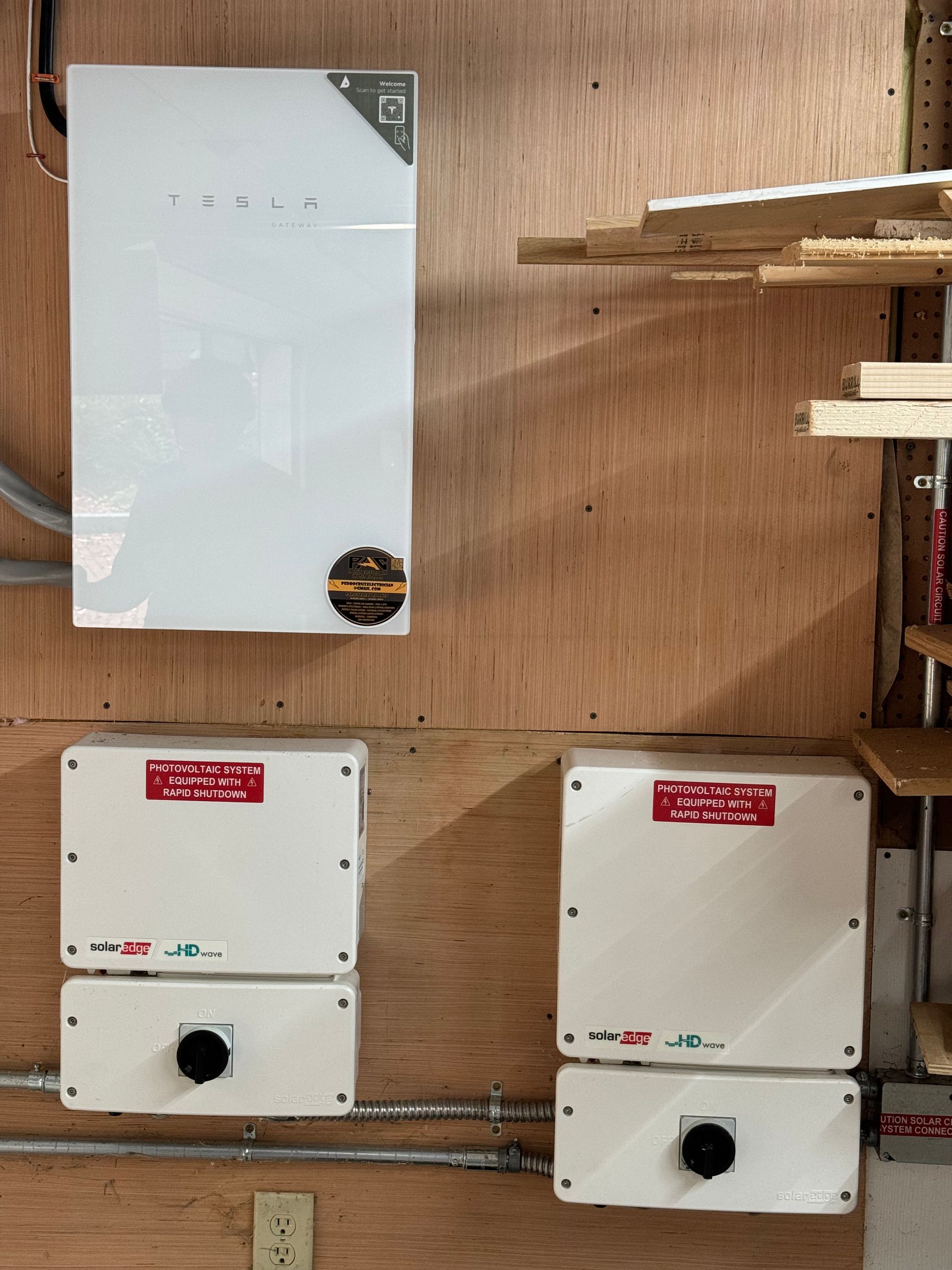 Two white boxes are sitting on a wooden wall.