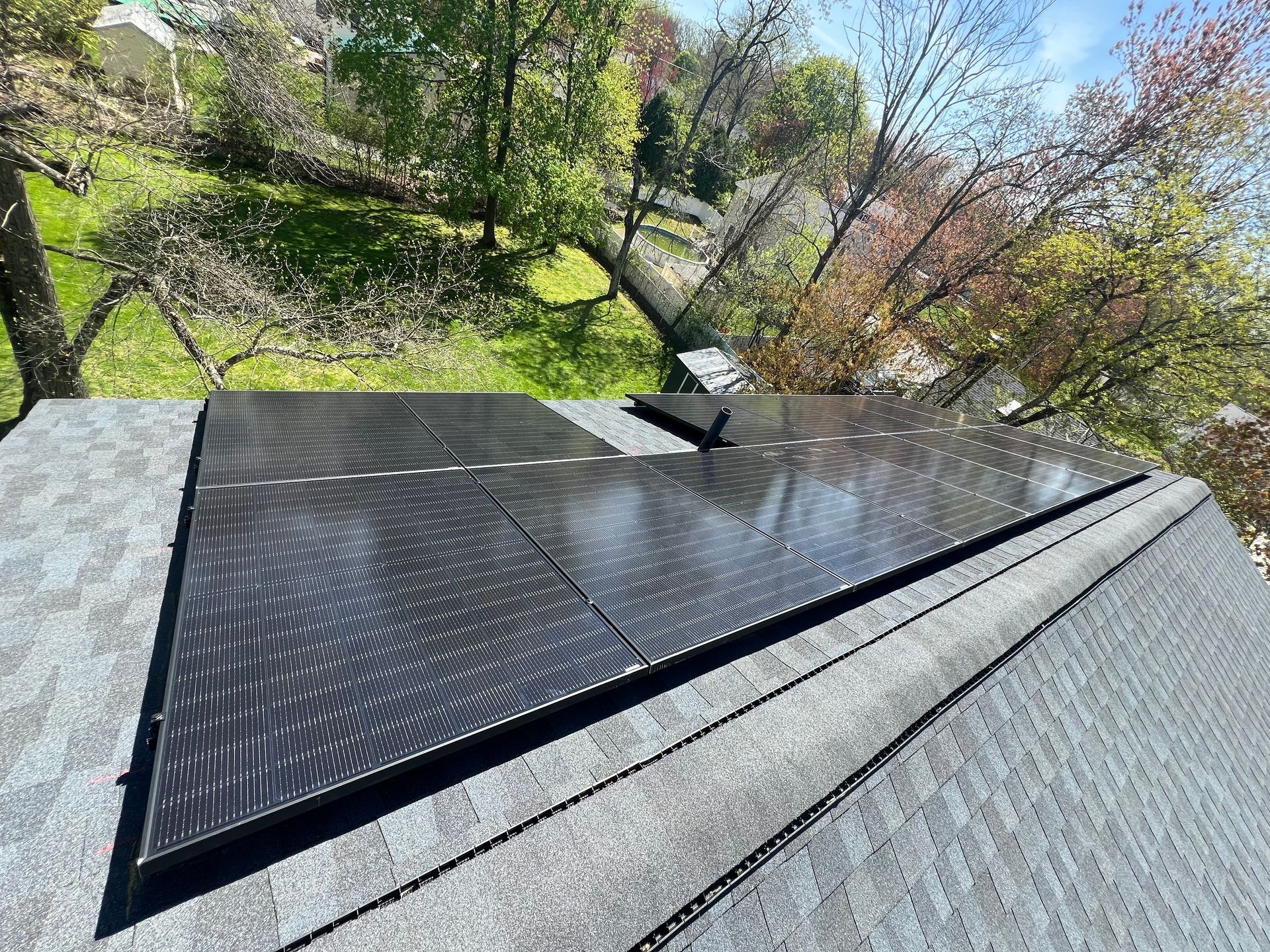 A triangle shaped solar panel is sitting on top of a roof.