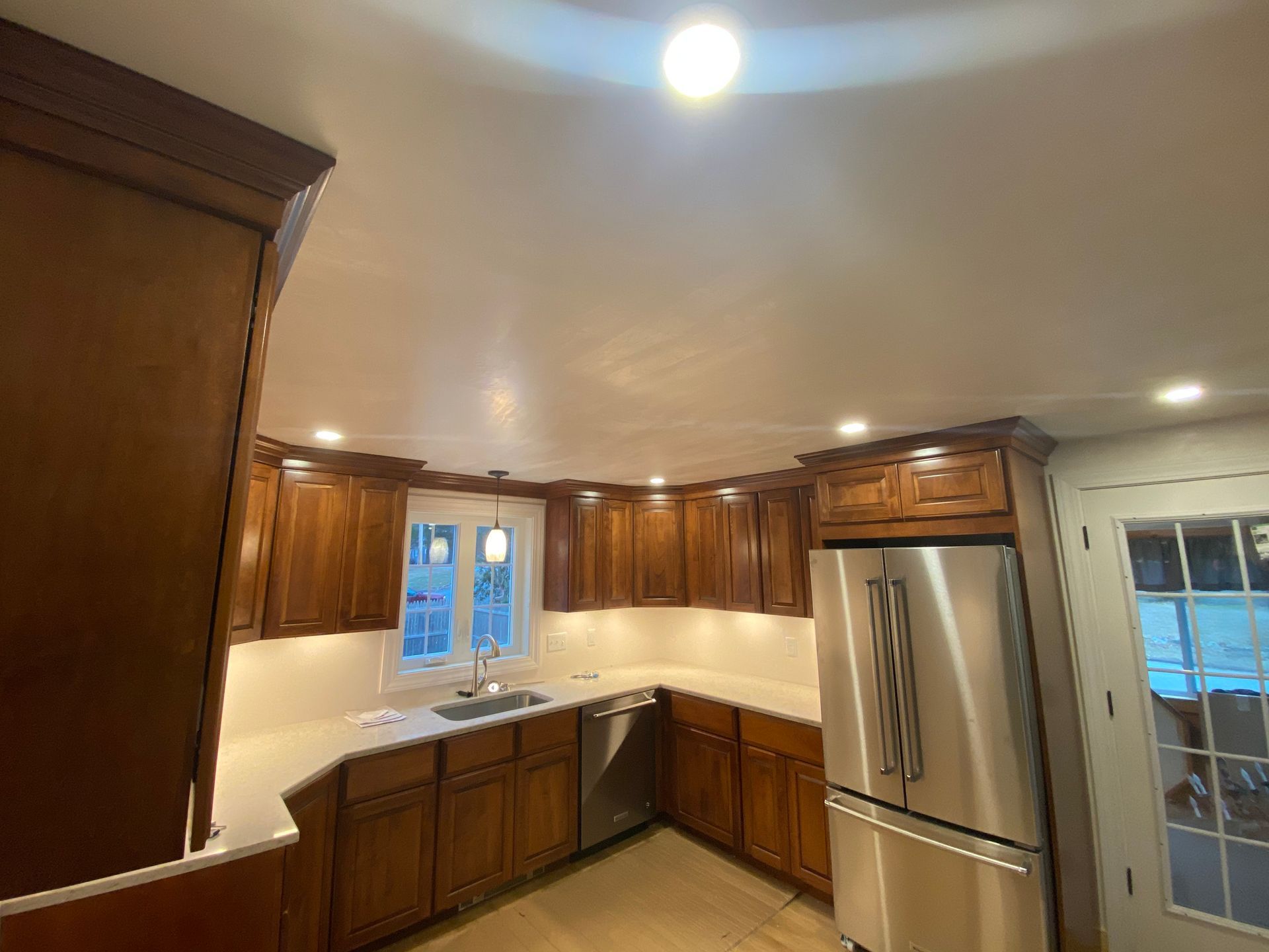 A kitchen with stainless steel appliances and wooden cabinets.