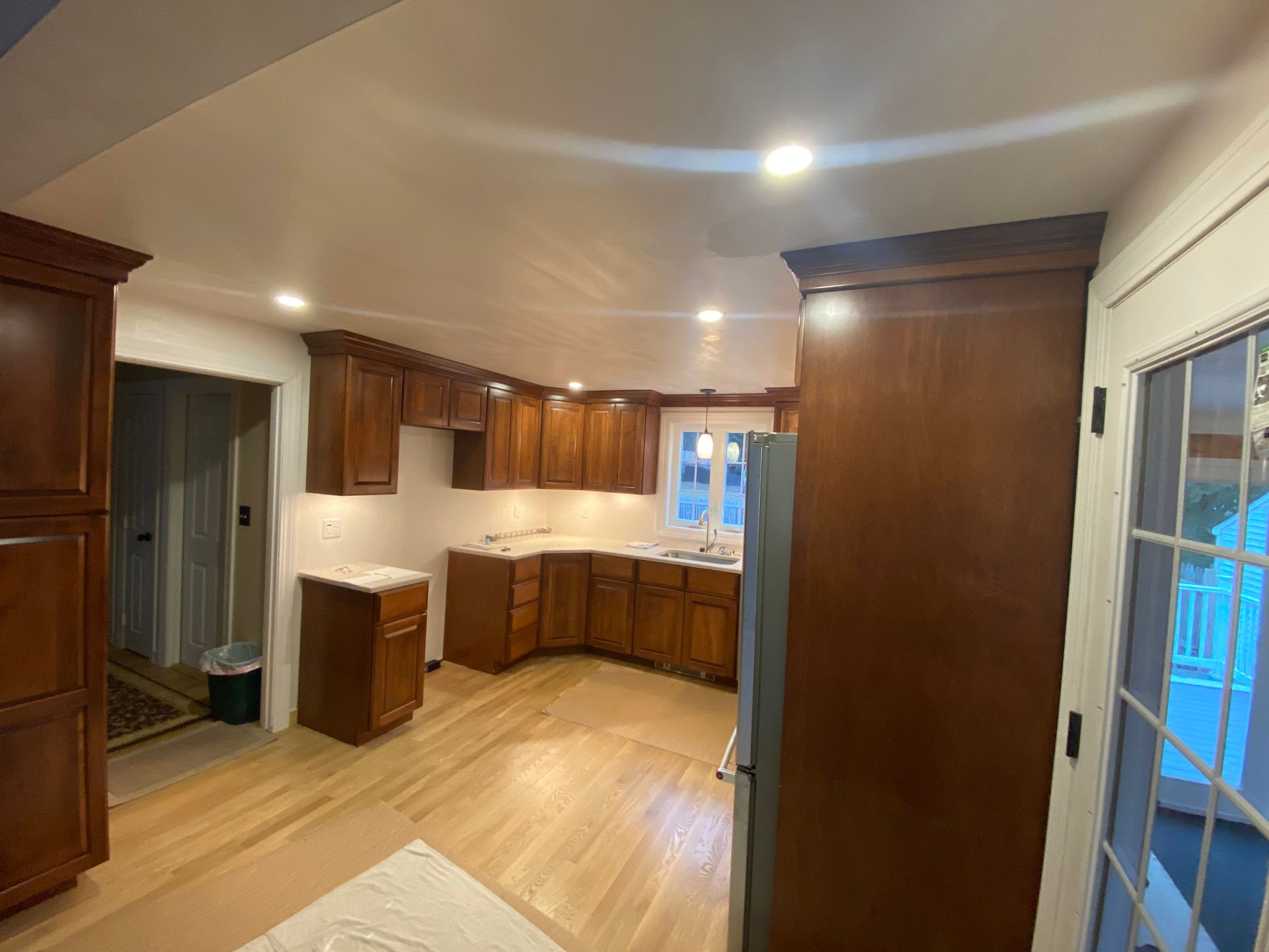 A kitchen with wooden cabinets and hardwood floors is being remodeled.