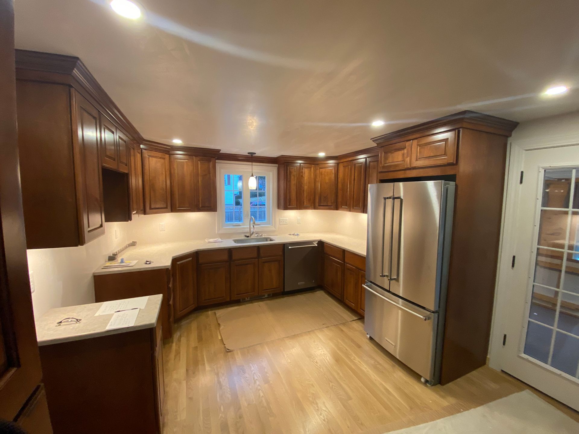 A kitchen with stainless steel appliances and wooden cabinets.