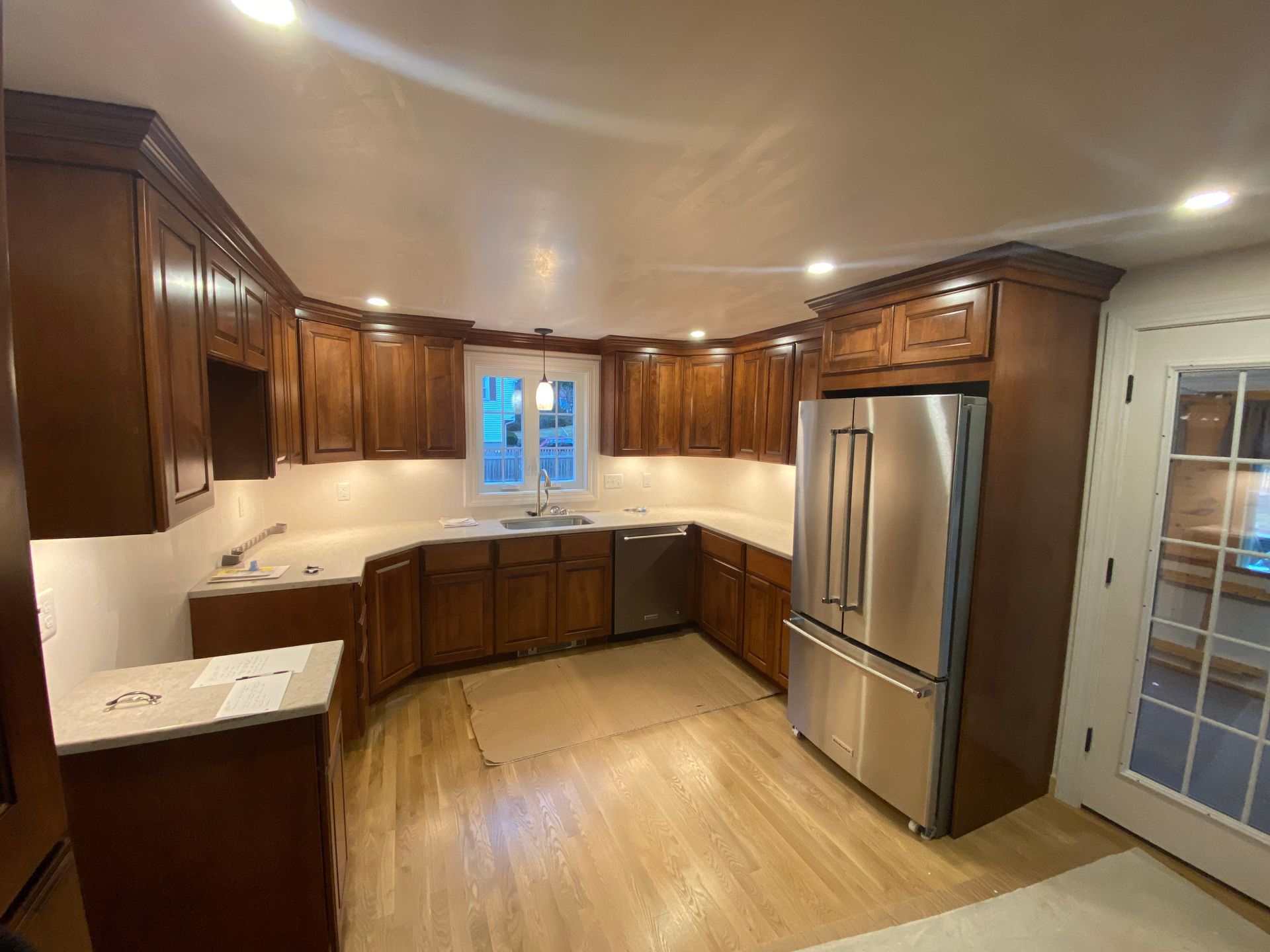 A kitchen with stainless steel appliances and wooden cabinets.