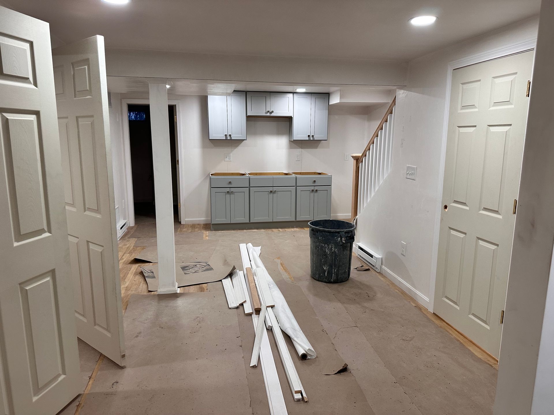 A basement with a kitchen and stairs under construction.