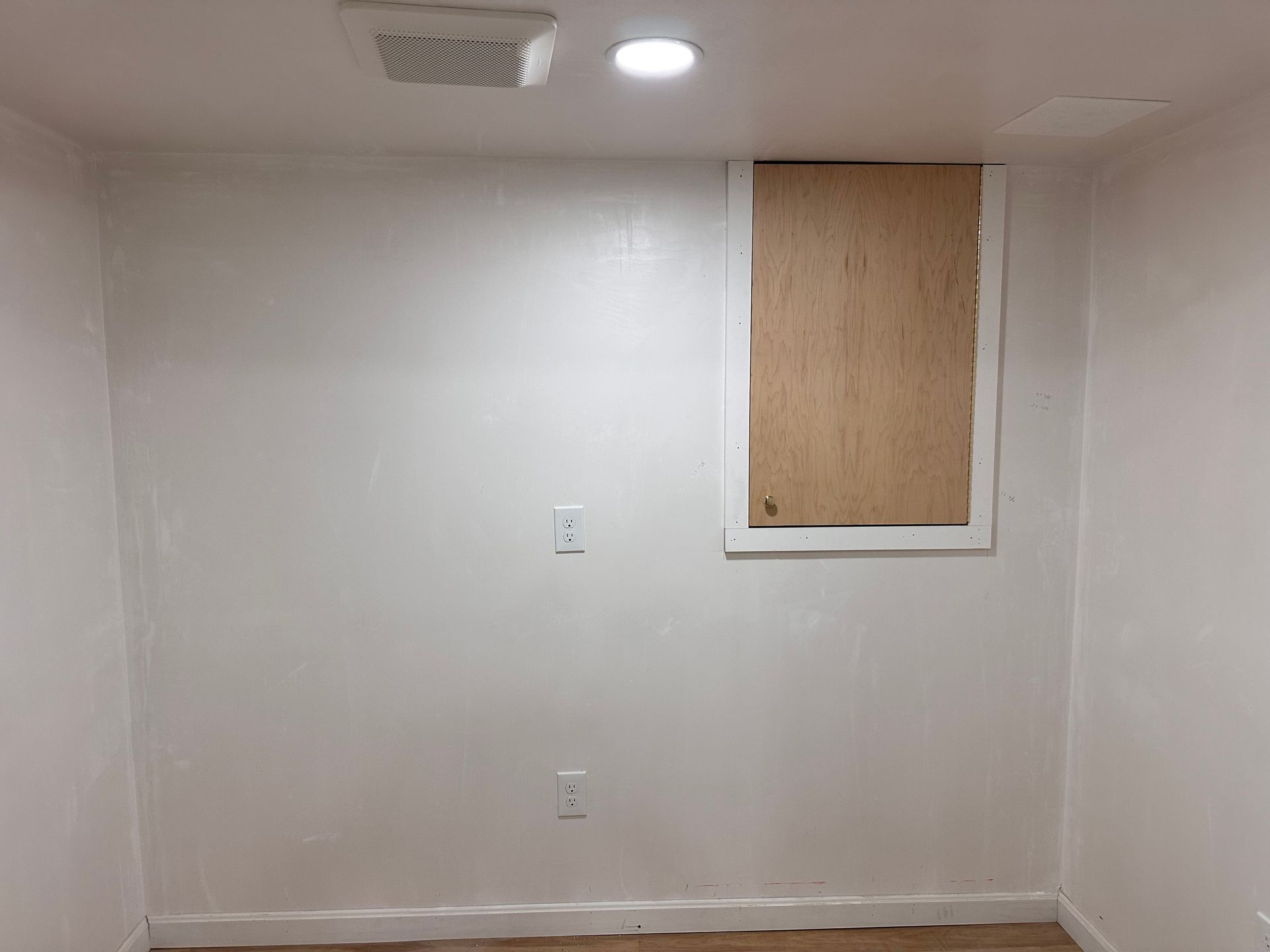 A room with white walls and a window in the corner.