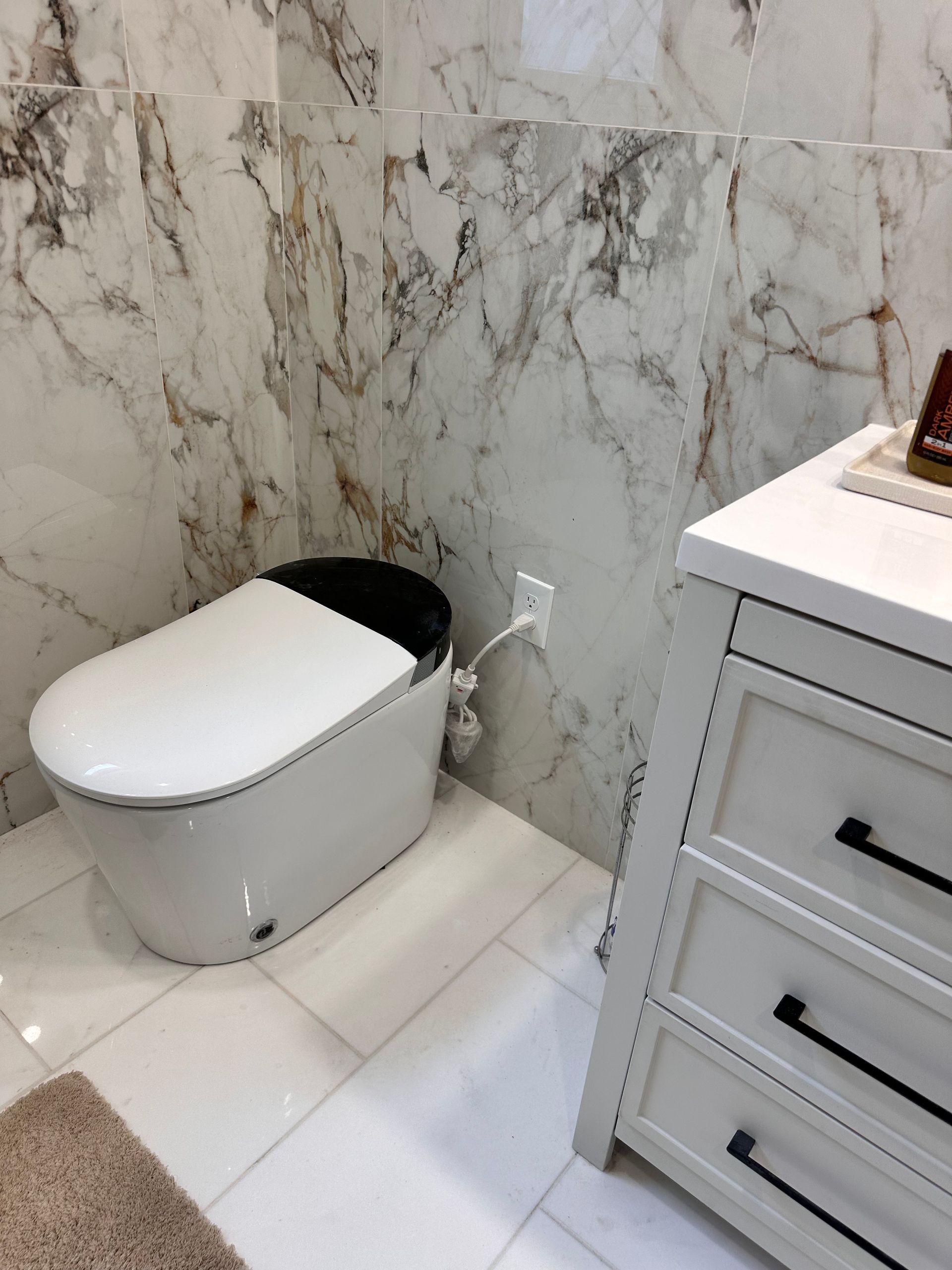 A bathroom with a toilet and a dresser