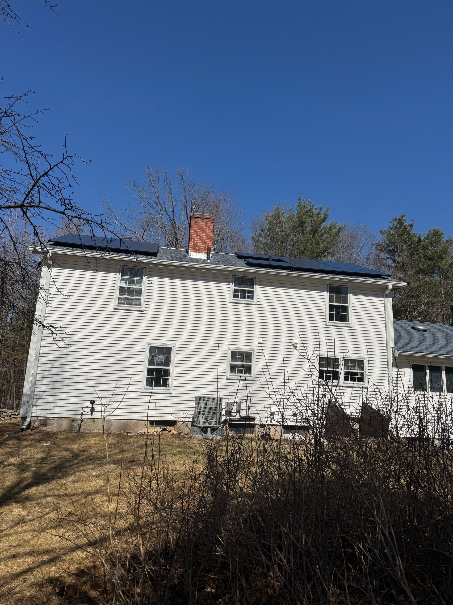 A white house with solar panels on the roof