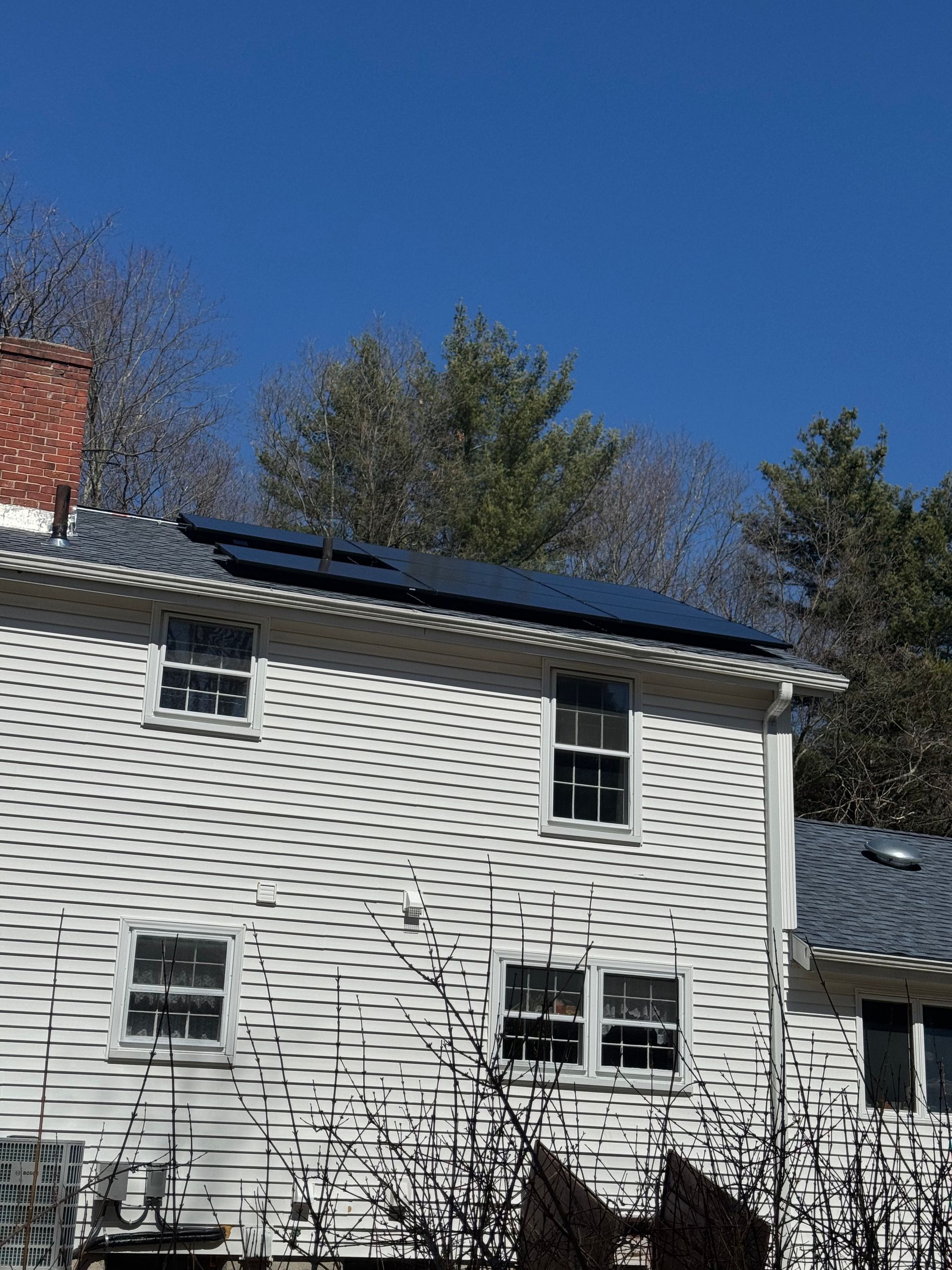 A white house with solar panels on the roof