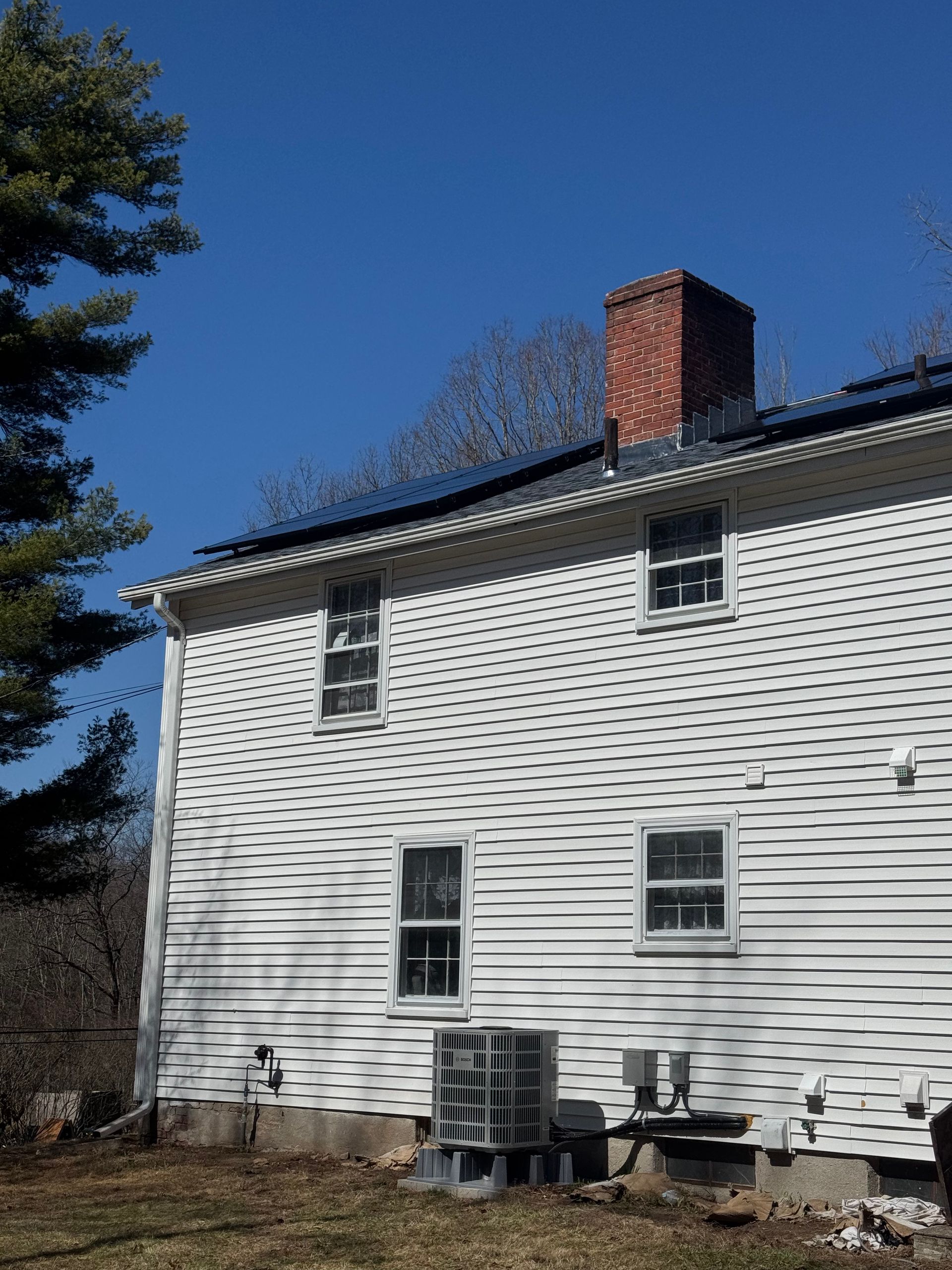 A white house with a chimney on top of it
