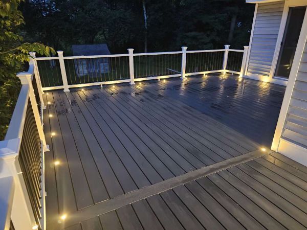 A deck with lights on it and a white railing