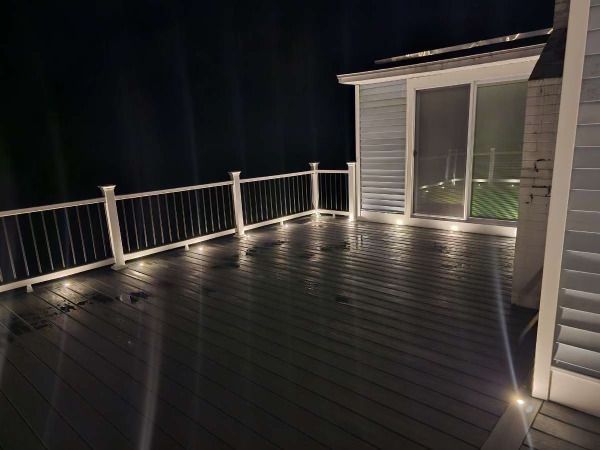 A deck with lights on it is lit up at night.