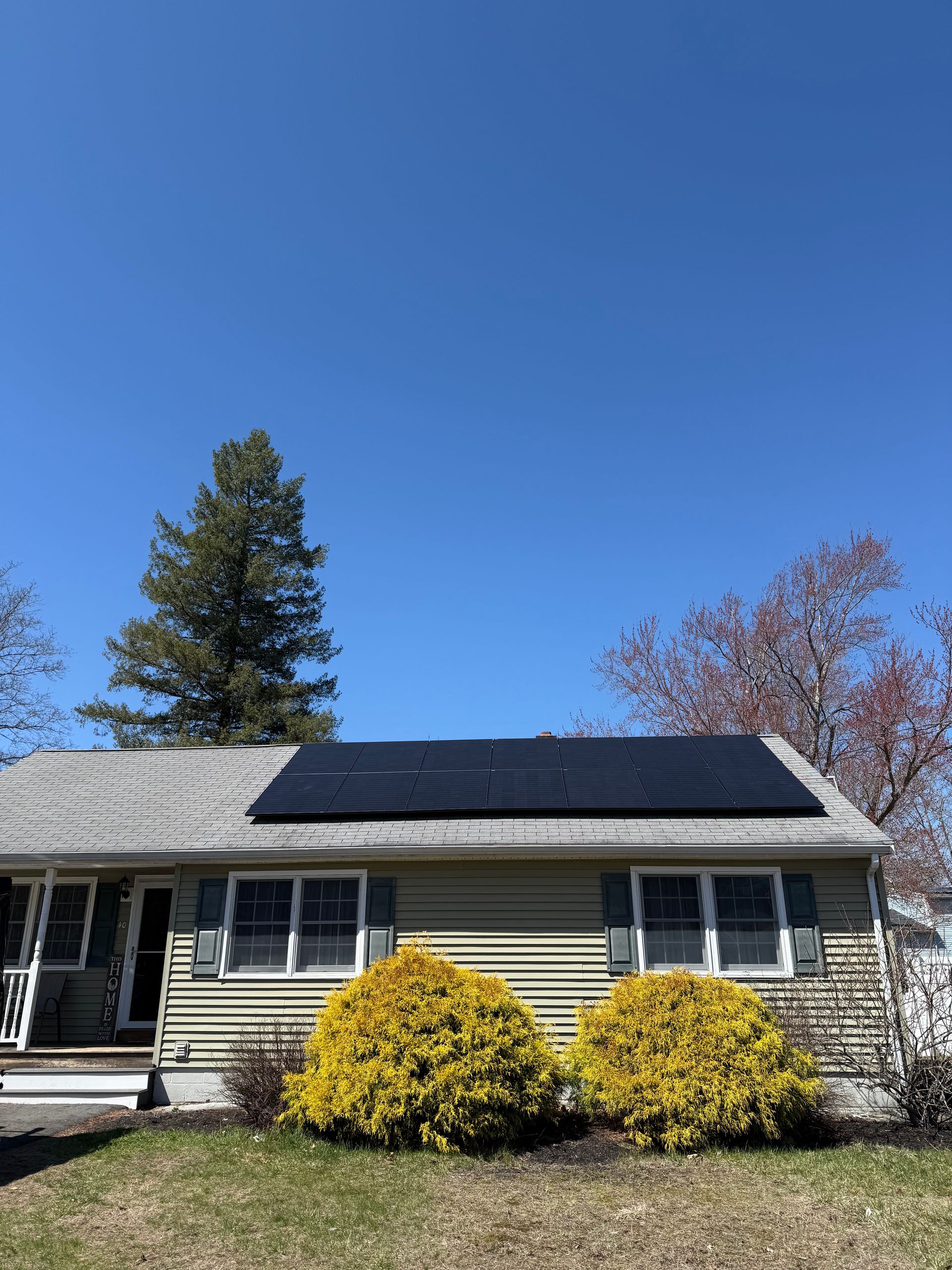 A house with solar panels on the roof on a sunny day.