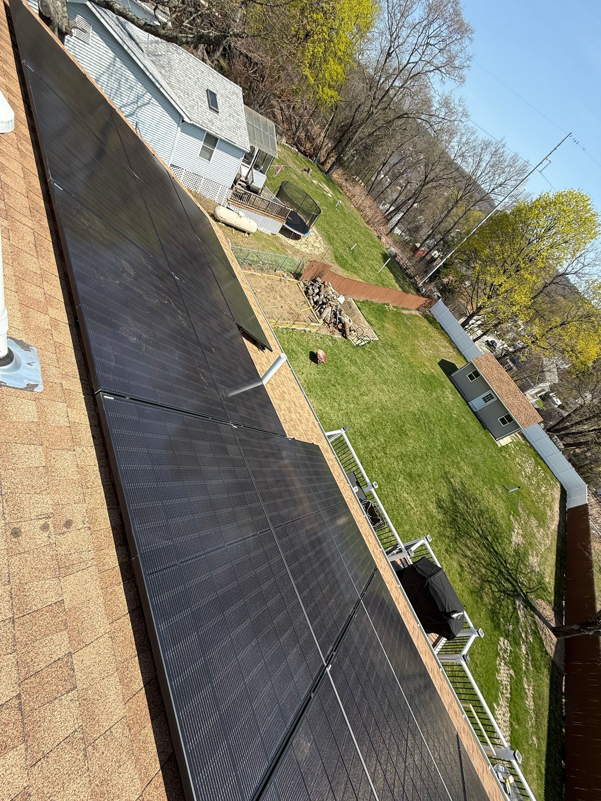 The roof of a house is being painted black.