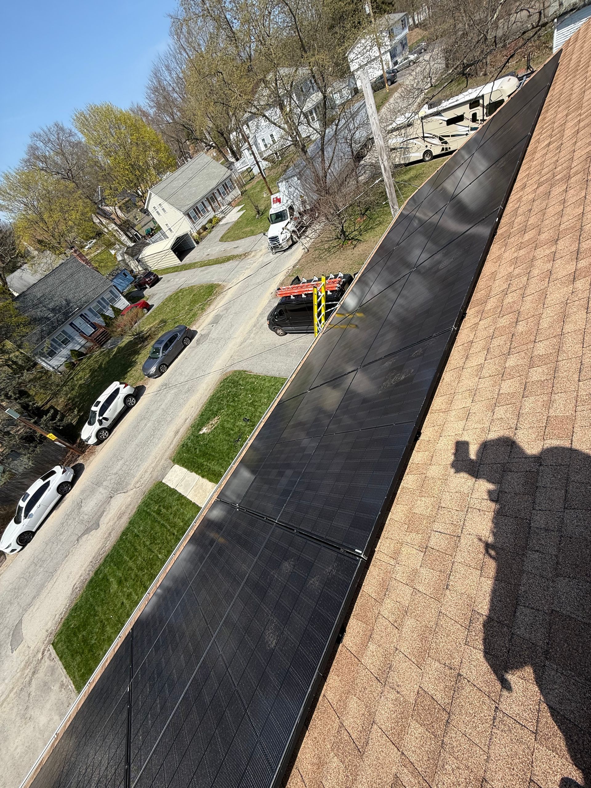 An aerial view of a roof with a shadow of a person on it.