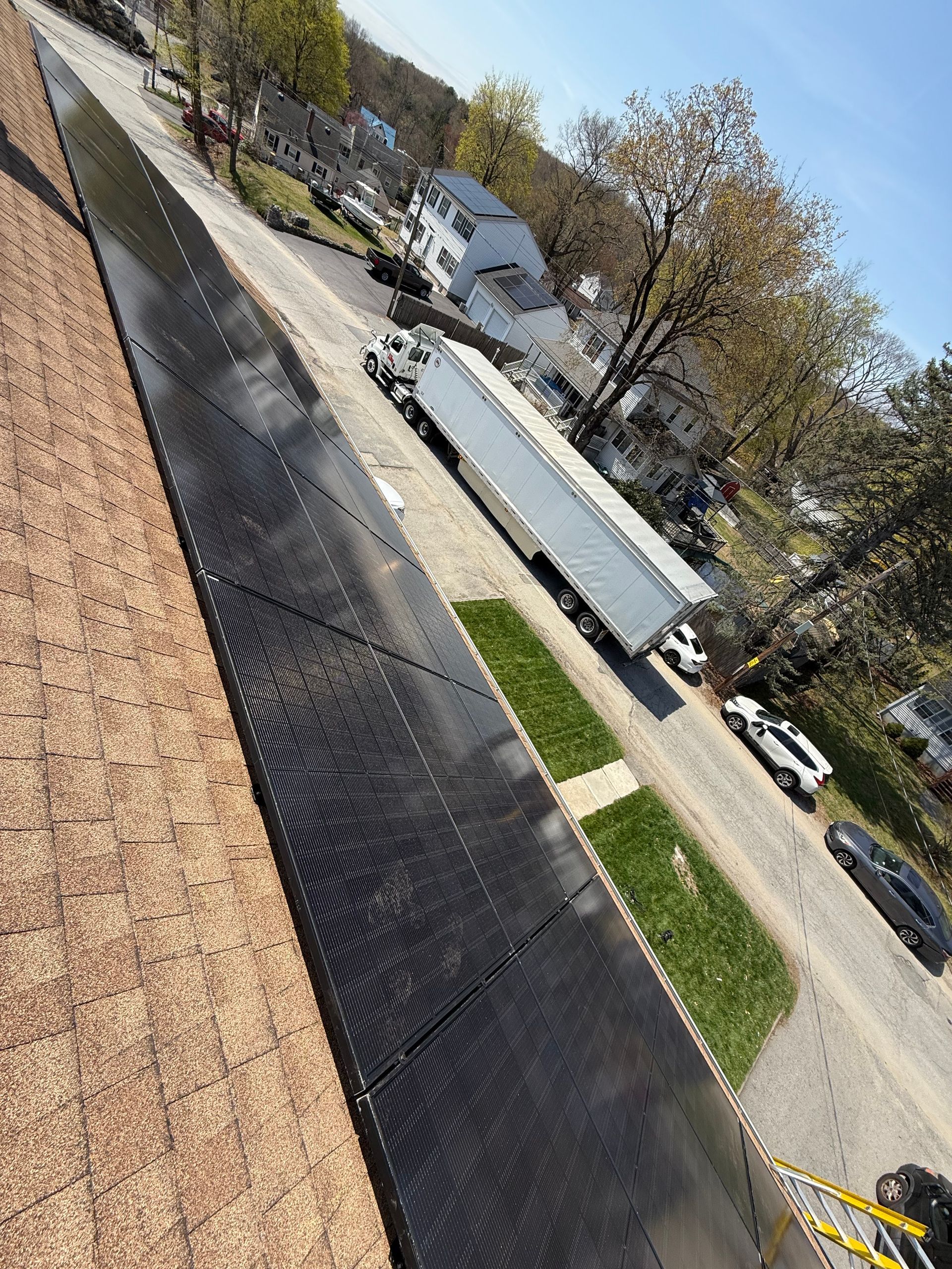 A truck is parked on the side of the road next to a row of solar panels.